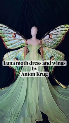 a mannequin dressed in a green dress with butterfly wings