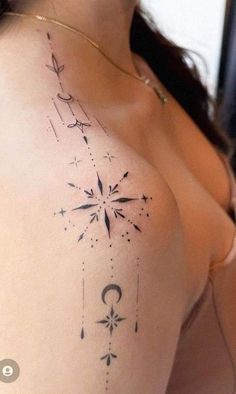 a woman's chest with an arrow and stars tattoo on it, as well as the moon