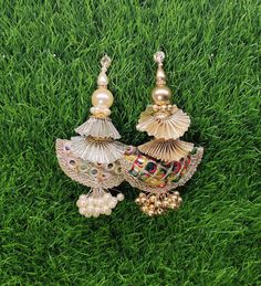 two pairs of earrings sitting in the grass