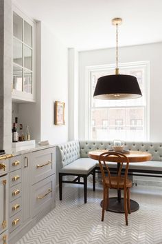 a dining room table and bench in front of a window