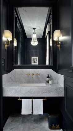 a bathroom with black walls and marble counter tops