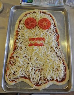 a pizza with cheese and tomatoes on it in a metal pan, ready to be baked