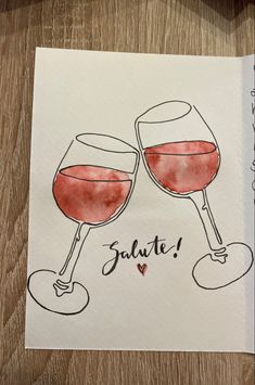 two glasses of red wine with the words salute written on them in cursive writing