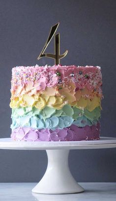 a cake that has the number four on it and is decorated with multicolored icing