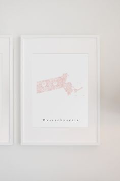 two framed pictures hang on the wall next to each other, one with a pink map