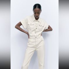 Long Jumpsuit With Lapel Collar And Turned Up Sleeves. Front Patch Pockets With Buttoned Flap At Chest And Back Patch Pocket. Straight Leg. Front Metal Button Closure. Outer Shell 100 % Chic Spring Overalls With Pockets, Trendy White Relaxed Fit Jumpsuits And Rompers, Chic Zara Jumpsuits And Rompers With Pockets, Chic Denim Jumpsuit For Summer Workwear, Fitted Beige Overalls For Spring, Chic Fitted White Overalls, White Overall Jumpsuits And Rompers With Pockets, Cream Cotton Jumpsuits And Rompers With Pockets, White Overalls Jumpsuit With Pockets