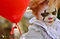 a clown holding a red balloon with his face painted like a clown's head