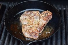 two steaks cooking in a skillet on the grill