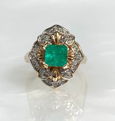 A regal Colombian emerald ring with divine floral detailing featuring a vibrant square emerald cut center stone weighing 1.20 carats surrounded by 0.16 carats of sparkling pave diamonds set in solid 14k yellow gold. *Ring size: 7 1/4 * Emerald measures 6mm all around * Ring weight: 7.41 grams Vintage Emerald Cut Emerald Ring With Halo Setting, Collectible Emerald Cut Green Emerald Ring, Heirloom Emerald Cut Emerald Cluster Ring, Vintage Emerald Cut Gemstone Cluster Ring, Vintage Emerald Cut Cluster Ring With Gemstone, Elegant Emerald Cut Emerald Ring For Collectors, Elegant Collectible Emerald Cut Emerald Ring, Elegant Emerald Cut Emerald Ring, Vintage Emerald Cut Cluster Ring