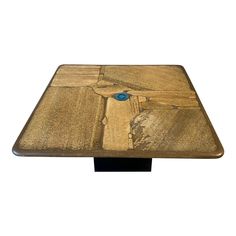 a wooden table with a blue object on it's top and black metal base