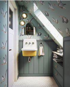 a bathroom with green walls and white sink under a slanted skylight in the corner