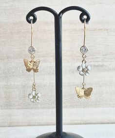 These dainty butterfly earrings with flowers are made of the followings: (1) Matt gold plated butterfly charm (Size: 8 x 10mm) (2) gold plated enamel flowers charm (size: 9 x 8mm) (3) gold plated earring hooks with cubic zirconia The total length of the earrings is about 47mm. ✏️ Please choose your desired color of flower 【BEFORE PURCHASE, PLEASE NOTE THE FOLLOWINGS】 ☆ VAT, GST and any other taxes from your country are NOT included in the listing price. Buyers are responsible for any aforesaid t Dainty Butterfly Earrings For Wedding, White Butterfly Charm Earrings For Wedding, White Dainty Butterfly Earrings, Whimsical White Butterfly Jewelry, Dainty White Butterfly Earrings, Delicate Gold Earrings With Butterfly Charm, White Drop Earrings With Butterfly Charm, Elegant Dangle Earrings With Butterfly Charm, Butterfly Dangle Earrings Gold