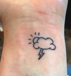 a small tattoo on the ankle of a woman's foot with a cloud and lightning