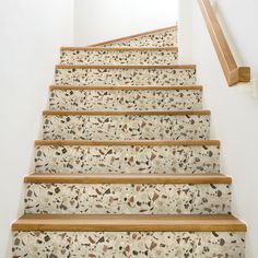 a set of stairs leading up to a second floor with white walls and wood handrails