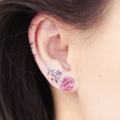 a close up of a person's ear with flowers on it