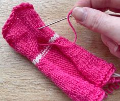 someone is knitting something with pink yarn