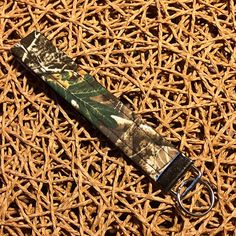 a keychain with a camo design on it sitting on a woven surface