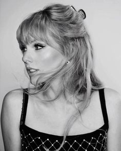 a black and white photo of a woman with her hair blowing in the wind