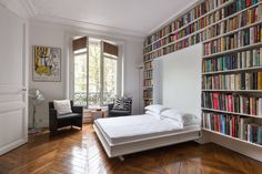 a bedroom with bookshelves and a bed in it