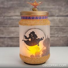 a glass jar filled with sand and a silhouette of a couple on top of it