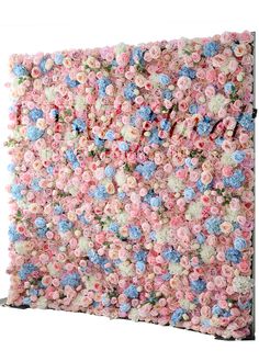 a pink and blue flowered wall hanging on the side of a white wall,