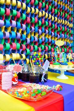 a colorful party table with candy and confetti