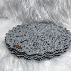 three crocheted placemats on white fur