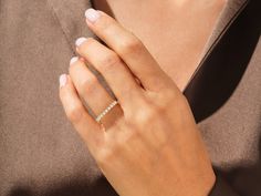 a woman's hand with a diamond ring on her left wrist, wearing a brown shirt