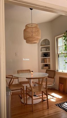 a dining room table and chairs in front of a window with the word home written on it