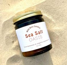 a jar of sea salt sits on the sand