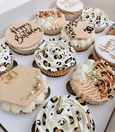 a box filled with cupcakes covered in frosting and decorated with leopard print