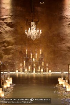 a wedding setup with candles and chandelier in the middle, surrounded by stone walls