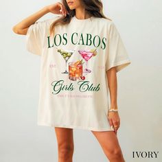 a woman wearing a t - shirt that says los cabos girls club on it