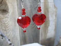 This is a fun pair of earrings which can be worn out to a special event, to a wedding, to dress up a casual outfit or semi formal outfits.  The elegant earrings feature a 20mm red cut glass crystal, two small red beads, a red bicone crystal, a rhinestone spacer and silver tone findings.  These earrings measure approximately 2 1/4" from the top of the lever back ear wire to the bottom.  The earrings in the photo are the exact pair you will receive and are ready to ship.  Designed and handcrafted by me for you in my smoke free studio. No returns accepted but please contact me should there be a problem with your order. Carefully packaged and shipped in a white box enclosed in a bubble lined envelope.  Free shipping is USPS Ground Advantage with tracking.  Estimated delivery is 2-6 days. Nickel Free Red Crystal Earrings For Parties, Red Heart Beads Earrings For Party, Valentine's Day Beaded Drop Earrings For Party, Valentine's Day Party Beaded Drop Earrings, Elegant Red Heart Beads Earrings, Elegant Beaded Earrings With Heart Beads For Parties, Elegant Party Earrings With Heart Beads, Elegant Beaded Earrings For Valentine's Day Party, Elegant Heart Beaded Dangle Earrings