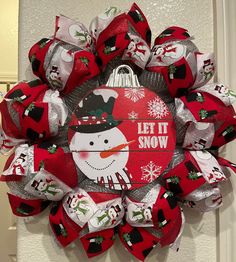 a red and white christmas wreath with a snowman on it