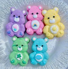 four teddy bears are sitting in a bowl with frosting on it's sides