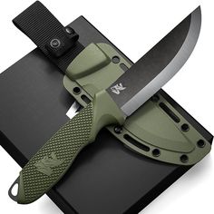 a green knife sitting on top of a black box