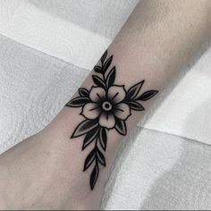 a black and white flower tattoo on the ankle