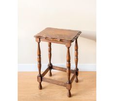 an old wooden table with two legs and a small shelf on the top that has been turned into a side table