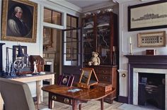 a living room filled with furniture next to a fire place and a painting on the wall