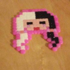 an image of a pixel head made out of pink and black beads on a table