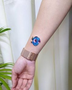 a person's arm with a tattoo on it and a small blue eyeball