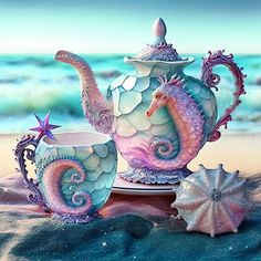 a tea set with seahorses and shells on the beach