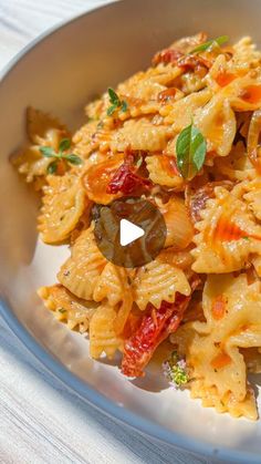 a bowl filled with pasta and vegetables on top of a table