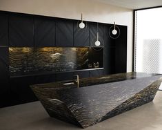 a large black and gold bathtub in a bathroom next to a wall mounted sink