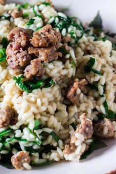 a white plate topped with rice and meat covered in spinach leafy sauce on top of it