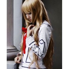 a woman with long blonde hair wearing a white shirt and red tie standing next to columns