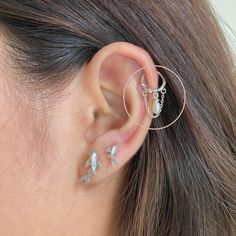 a close up of a person's ear with two piercings attached to it