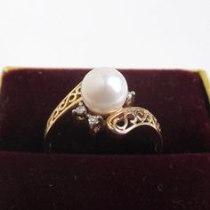 A beautiful vintage 14K solid gold ring with large pearl center and four colorless stones.  I believe the pearl is genuine though I'm not an expert (I haven't had the colorless stones tested at all).  Nice filigree setting.  Marked "14KP" and "T&C".  Pearl is 6mm in diameter.  Ring is a size 6 1/2 on my ring sizer.  2.7 grams.Please check out my store with similar things added almost daily.Remember, shipping for additional items is always free. Antique 14k Stamped Pearl Ring Gift, Heirloom Pearl Ring Stamped 14k As Gift, White Art Nouveau Jewelry For Anniversary, Victorian Yellow Gold Pearl Ring Gift, Victorian Style Gold Pearl Ring For Formal Events, Antique Round Pearl Ring As Gift, Victorian Style 14k Gold Pearl Ring For Anniversary, Victorian 14k Gold Pearl Ring Gift, Victorian 14k Gold Pearl Wedding Ring