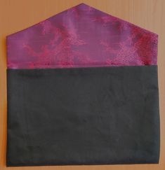 a black and purple piece of cloth sitting on top of a wooden table next to a brown wall